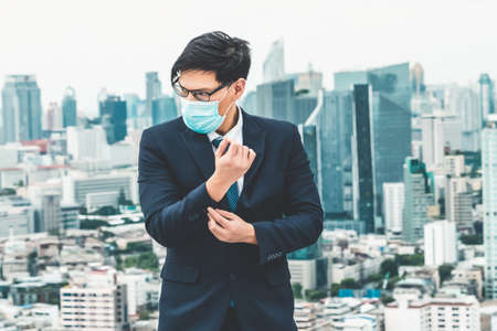 Young office worker with face mask quarantine from coronavirus or COVID-19. Concept of protective working environment to reopen business and stop spreading of coronavirus or COVID-19.の写真素材