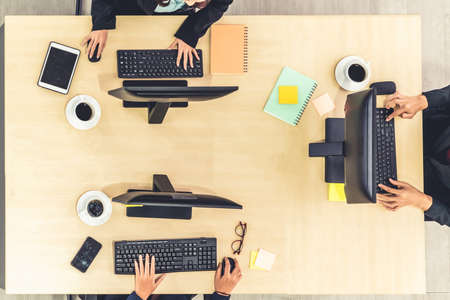 Business people wearing headset from top view in office working with computer to support remote customer or colleague. Call center, telemarketing agent service on telephone or video conference call.の写真素材