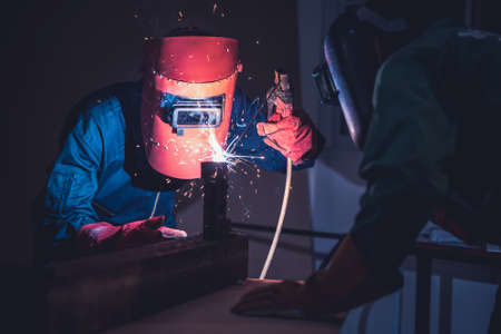 Metal welding steel works using electric arc welding machine to weld steel at factory. Metalwork manufacturing and construction maintenance service by manual skill labor concept.の写真素材