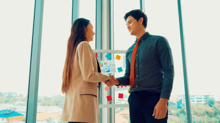 Business people handshake in corporate office showing professional agreement on a financial deal contract.の写真素材