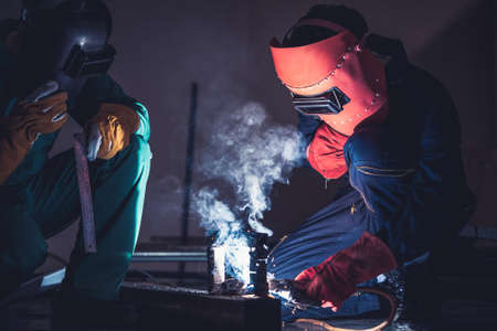 Metal welding steel works using electric arc welding machine to weld steel at factory. Metalwork manufacturing and construction maintenance service by manual skill labor concept.の写真素材