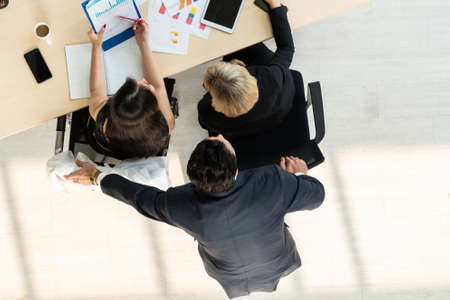Business people group meeting shot from top view in office . Profession businesswomen, businessmen and office workers working in team conference with project planning document on meeting table .の写真素材