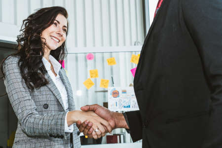Business people handshake in corporate office showing professional agreement on a financial deal contract.の写真素材