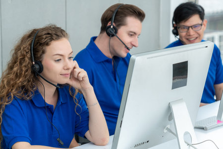 Business people wearing headset working in office to support remote customer or colleague. Call center, telemarketing, customer support agent provide service on telephone video conference call.の写真素材