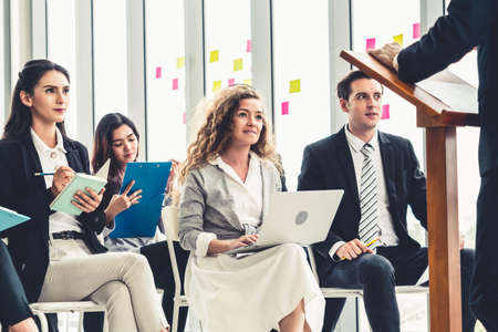 Group of business people meeting in a seminar conference . Audience listening to instructor in employee education training session . Office worker community summit forum with expert speaker .の写真素材