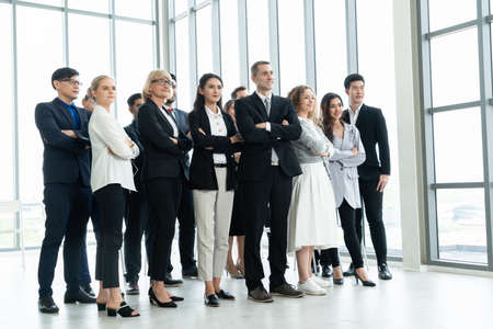 Successful business people standing together showing strong relationship of worker community. A team of businessman and businesswoman expressing a strong group teamwork at the modern office.の写真素材