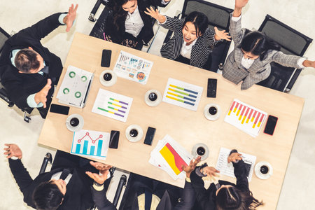 Successful business people celebrate together with joy at office table shot from top view . Young...