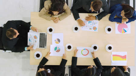 Business people group meeting shot from top view in office . Profession businesswomen, businessmen and office workers working in team conference with project planning document on meeting table .の写真素材