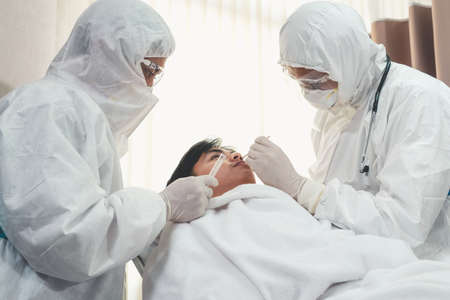 Doctor obtain Nasopharyngeal Swab Specimen to test covid 19 or coronavirus infection from patient . Covid-19 medical examination staff service concept .の写真素材