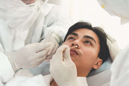 Doctor obtain Nasopharyngeal Swab Specimen to test covid 19 or coronavirus infection from patient . Covid-19 medical examination staff service concept .の写真素材