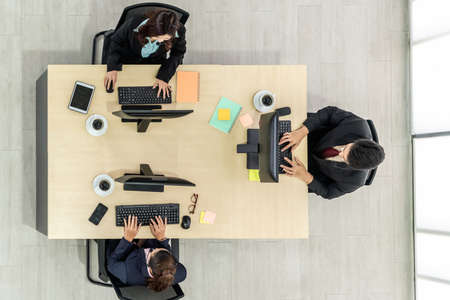 Business people wearing headset from top view in office working with computer to support remote customer or colleague. Call center, telemarketing agent service on telephone or video conference call.の写真素材