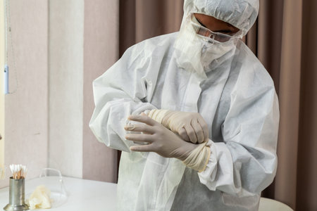 Doctor in PPE suit , face mask and face shield in hospital ward protected from Coronavirus and...