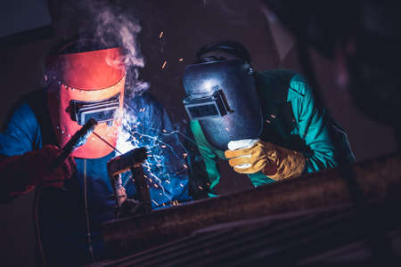 Metal welding steel works using electric arc welding machine to weld steel at factory. Metalwork manufacturing and construction maintenance service by manual skill labor concept.の写真素材