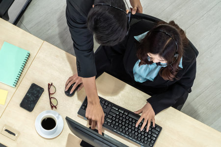 Business people wearing headset from top view in office working with computer to support remote...