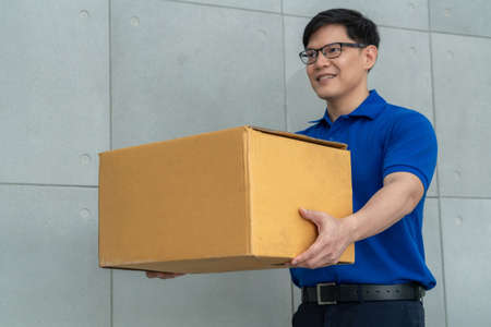 Delivery person carrying parcel box to send to customer . Delivery business concept .の写真素材