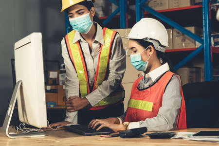 Factory industry worker working with face mask to prevent Covid-19 Coronavirus spreading during job reopening period .の写真素材