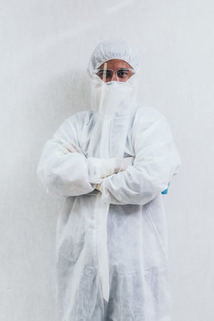 Doctor in PPE suit , face mask and face shield in hospital ward protected from Coronavirus and...