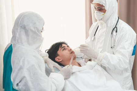 Doctor obtain Nasopharyngeal Swab Specimen to test covid 19 or coronavirus infection from patient . Covid-19 medical examination staff service concept .の写真素材