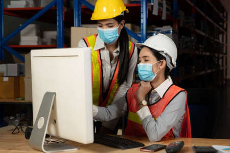 Factory industry worker working with face mask to prevent Covid-19 Coronavirus spreading during job reopening period .の写真素材