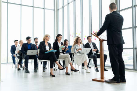 Group of business people meeting in a seminar conference . Audience listening to instructor in employee education training session . Office worker community summit forum with expert speaker .の写真素材