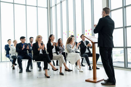 Group of business people meeting in a seminar conference . Audience listening to instructor in employee education training session . Office worker community summit forum with expert speaker .の写真素材