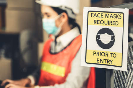 Caution sign in factory warning to industry labor worker to prevent Covid-19 Coronavirus spreading during job business reopening period after epidemic crisis . Working safely concept .の写真素材
