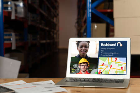 Warehouse staff talking on video call at computer screen in storage warehouse . Online software technology connects people working in logistic factory by virtual conference call on internet network .の写真素材
