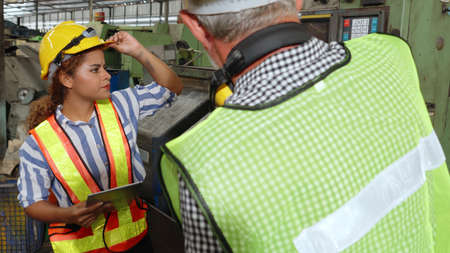 Group of factory workers using machine equipment in factory workshop . Industry and engineering concept .の写真素材