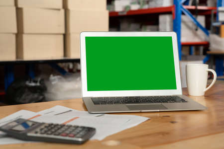Computer with green screen display in warehouse storage room . Delivery and transportation software concept .の写真素材