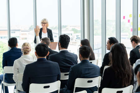 Group of business people meeting in a seminar conference . Audience listening to instructor in employee education training session . Office worker community summit forum with expert speaker .の写真素材