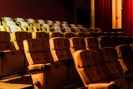 A row of yellow seat with popcorn on chair in the movie theaterの写真素材