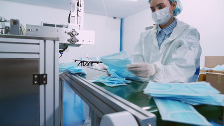 Face mask production line in modern factory . Concept of covid-19 coronavirus 2019 provention .