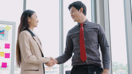Business people handshake in corporate office showing professional agreement on a financial deal contract.の写真素材