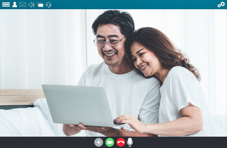 Happy senior people talking on internet video call at home while laughing with love . Online...
