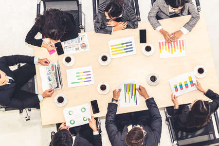 Business people group meeting shot from top view in office . Profession businesswomen, businessmen and office workers working in team conference with project planning document on meeting table .の写真素材