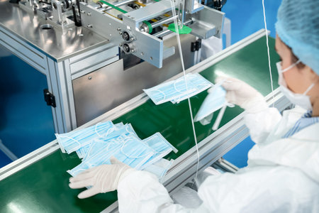Face mask production line in modern factory . Concept of covid-19 coronavirus 2019 provention .