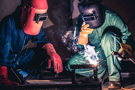 Metal welding steel works using electric arc welding machine to weld steel at factory. Metalwork manufacturing and construction maintenance service by manual skill labor concept.の写真素材