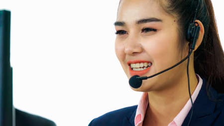 Business people wearing headset working in office to support remote customer or colleague. Call center, telemarketing, customer support agent provide service on telephone video conference call.の写真素材