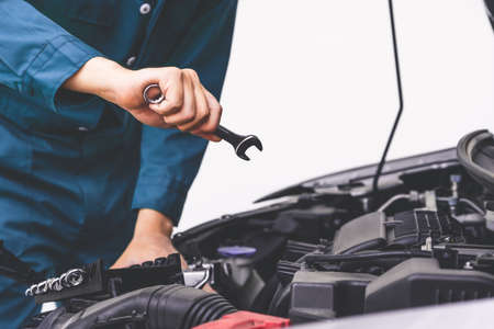 Professional mechanic hand providing car repair and maintenance service in auto garage. Car service business concept.の写真素材