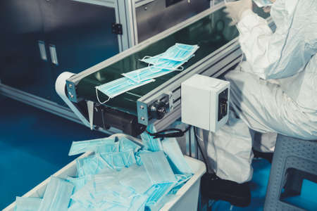 Face mask production line in modern factory . Concept of covid-19 coronavirus 2019 provention .の写真素材