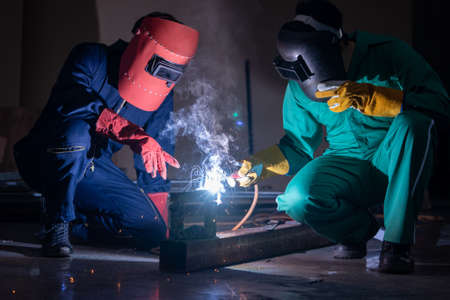 Metal welding steel works using electric arc welding machine to weld steel at factory. Metalwork manufacturing and construction maintenance service by manual skill labor concept.の写真素材