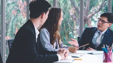 Smart businessman and businesswoman talking discussion in group meeting at office table in a modern...