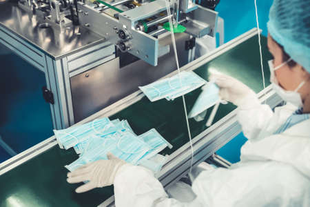 Face mask production line in modern factory . Concept of covid-19 coronavirus 2019 provention .の写真素材