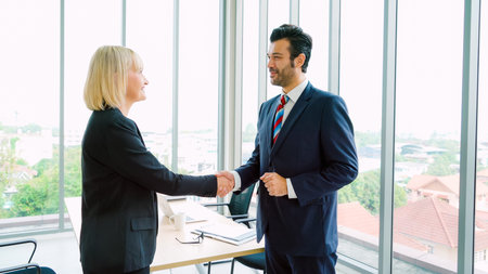 Business people handshake in corporate office showing professional agreement on a financial deal...