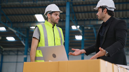 Two factory workers working and discussing manufacturing plan in the factory . Industry and...