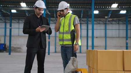 Two factory workers working and discussing manufacturing plan in the factory . Industry and...