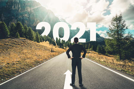 The 2021 New Year journey and future vision concept . Businessman traveling on highway road leading forward to happy new year celebration in beginning of 2021 for fresh and successful start .の写真素材