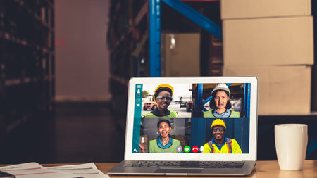 Warehouse staff talking on video call at computer screen in storage warehouse . Online software...