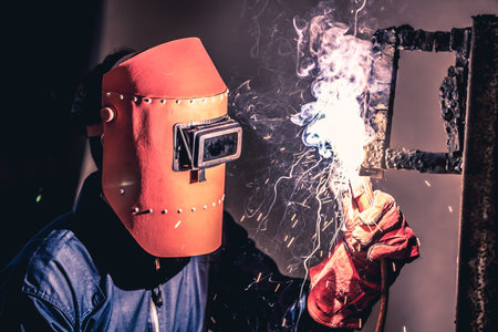 Metal welding steel works using electric arc welding machine to weld steel at factory. Metalwork...