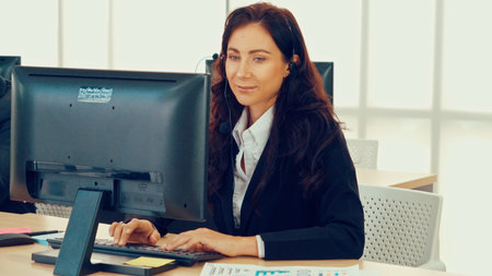 Business people wearing headset working in office to support remote customer or colleague. Call center, telemarketing, customer support agent provide service on telephone video conference call.の写真素材